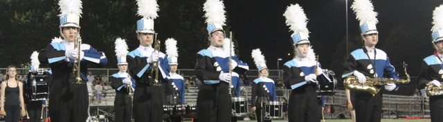 240913 Perf Clarinet Sax Members of the Yorktown High School Marching Band Woodwind and Brass Sections performing the halftime show. Students are wearing their YHS uniforms with black pants, Navy, white, black, and light blue tops and white and black hats with white plumes.