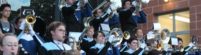 240913 Stand Band Tubas Members of the Yorktown High School Marching Band performing in the stands, including 3 shoulder-mounted tubas.. Students are wearing their YHS uniforms with black pants, Navy, white, black, and light blue tops and white and black hats with white plumes.